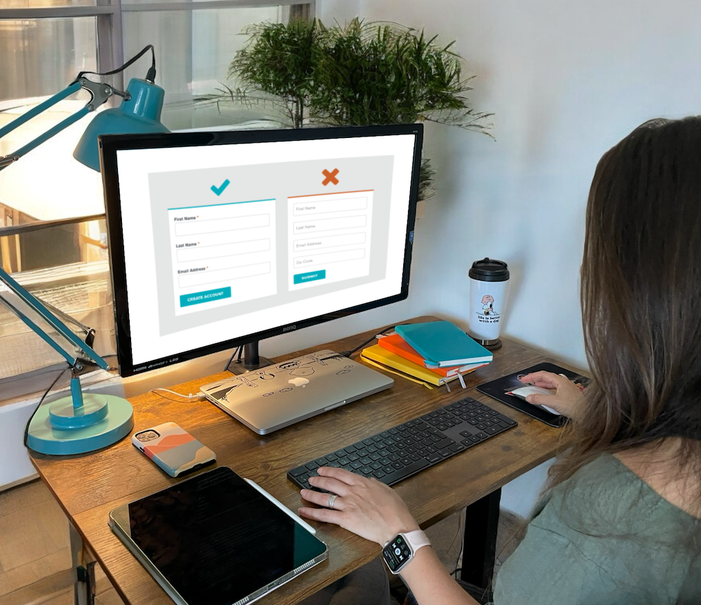 A person sat at a desk with two forms on screen, one with labels and one without.